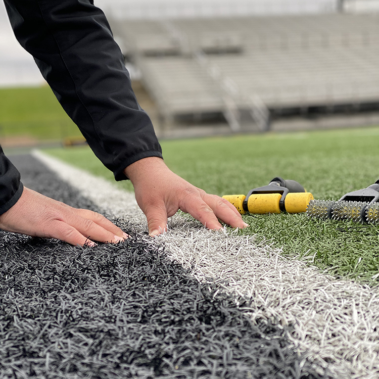 Photo of Tony working on a football field